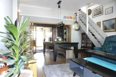 a living room with a blue couch and a piano at Aigas Cottage in Glasgow