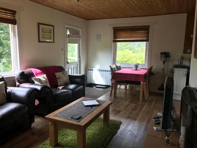 a living room with a couch and a table at Glengarry Lodge in Tyndrum