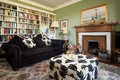 a living room with a couch and a fireplace at Mossfennan House in Drummelzier