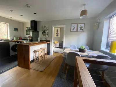a kitchen and living room with a table and a counter at Eakie House Apartments - Kinlochleven in Kinlochleven