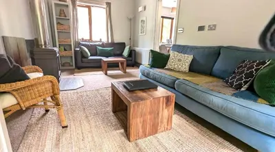 a living room with a blue couch and a table at Eakie House Apartments - Kinlochleven in Kinlochleven