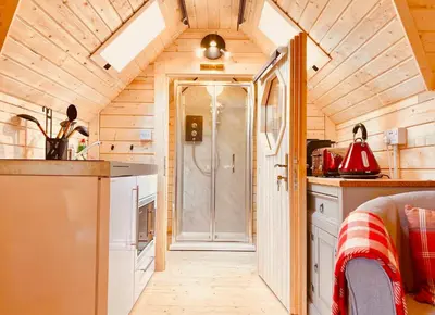a small kitchen with a shower in a tiny house at Seal Cove Cabin - Luxury Glamping in Cairndow