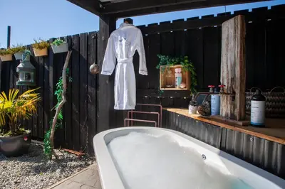 a robe hanging on a fence with a bath tub at The Carriage at Creagan in Creagan