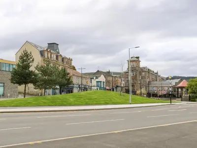 a town with a grassy hill in the middle of a street at Mars Hill Lower in Dunoon