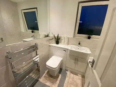 a bathroom with a toilet and a sink and a window at Culbin Lodge in Glasgow