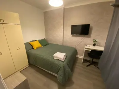 a bedroom with a bed and a desk and a television at Culbin Lodge in Glasgow