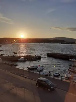 a van parked next to a body of water with boats at Wee Harbour View in Millport