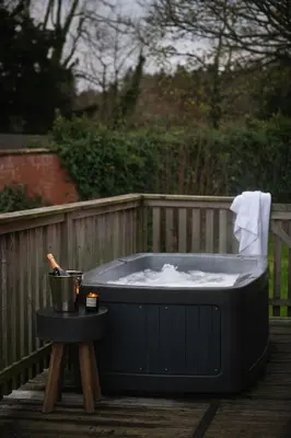 a black hot tub sitting on a deck at Kestrel Lodge 3 with Hot Tub in Newton Stewart