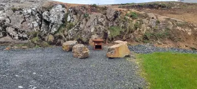 a bench sitting on top of some rocks at Fairhead Glamping Pods in Ballycastle