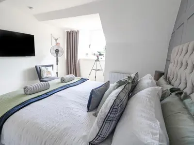 a bedroom with a large white bed with pillows at Ben View in Arrochar