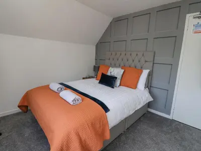 a bedroom with a bed with an orange blanket at Ben View in Arrochar