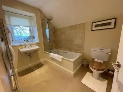 a bathroom with a tub and a toilet and a sink at Luxury Garden Cottage in Dalry