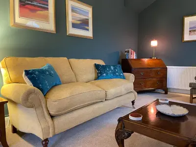 a living room with a couch and a coffee table at Luxury Garden Cottage in Dalry
