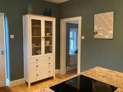 a kitchen with a white cabinet in a room at Luxury Garden Cottage in Dalry