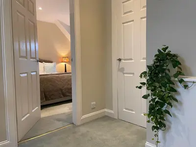 a bedroom with a bed and a door with a plant at Luxury Garden Cottage in Dalry