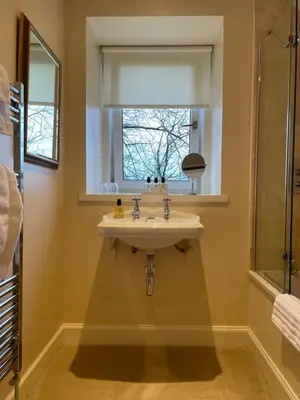 a bathroom with a sink and a window at Luxury Garden Cottage in Dalry