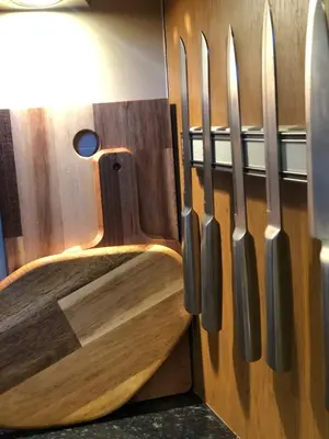 a row of knives hanging on a wooden wall at Lomond View in Luss