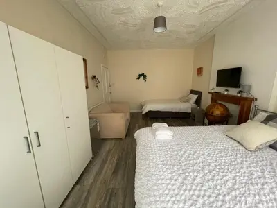 a bedroom with two beds and a living room at Earls Lodge in Whiteinch