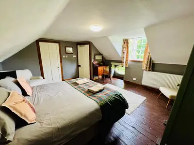 a bedroom with a large bed in a attic at East Cottage at Powis House Estate in Stirling