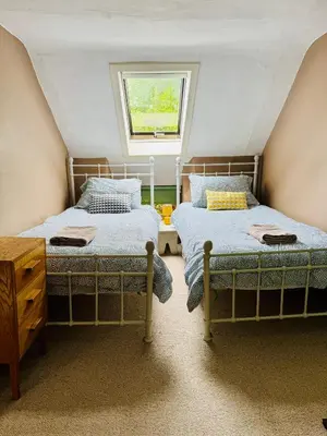 two beds in a small room with a window at East Cottage at Powis House Estate in Stirling