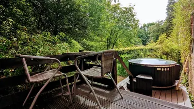 a pair of chairs and a barrel on a deck at East Cottage at Powis House Estate in Stirling