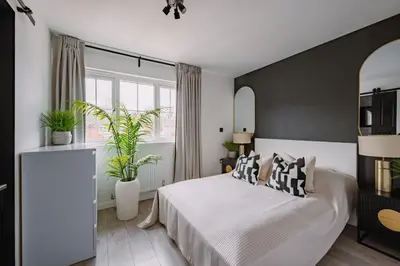 a bedroom with a bed and two potted plants at ComfySleep ApartHOUSE in Glasgow