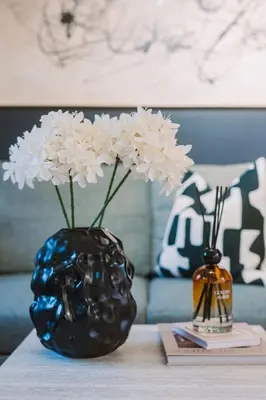 a blue vase with white flowers on a table at ComfySleep ApartHOUSE in Glasgow