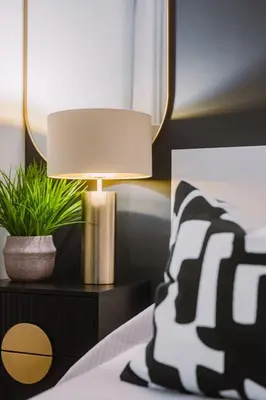 a lamp on a night stand next to a bed at ComfySleep ApartHOUSE in Glasgow