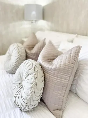 a pile of pillows on a white bed at Kenavara House in Oban