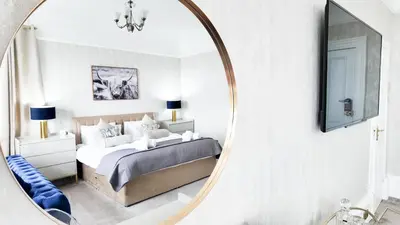 a bedroom with a bed and a mirror at Kenavara House in Oban