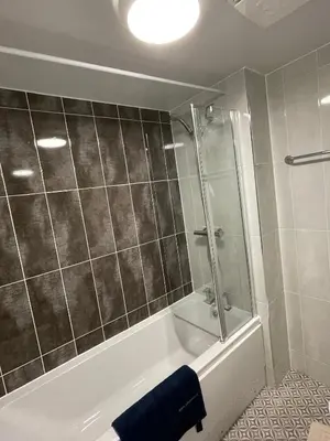 a bathroom with a shower and a bath tub at 3 bed house with parking near airport in Edinburgh