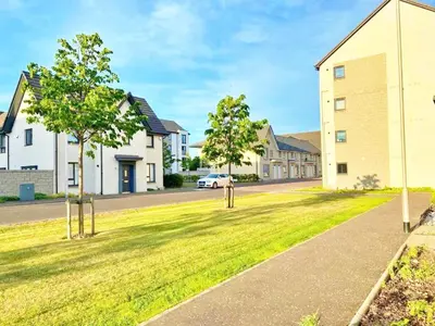 a street in a residential neighborhood with houses at 3 bed house with parking near airport in Edinburgh