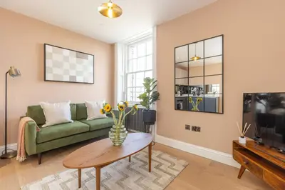 a living room with a green couch and a table at Dragon Suites Luxury Serviced Apartments at Walker Street in Edinburgh