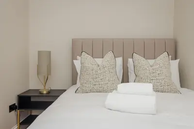 a bedroom with a white bed with pillows at Dragon Suites Luxury Serviced Apartments at Walker Street in Edinburgh